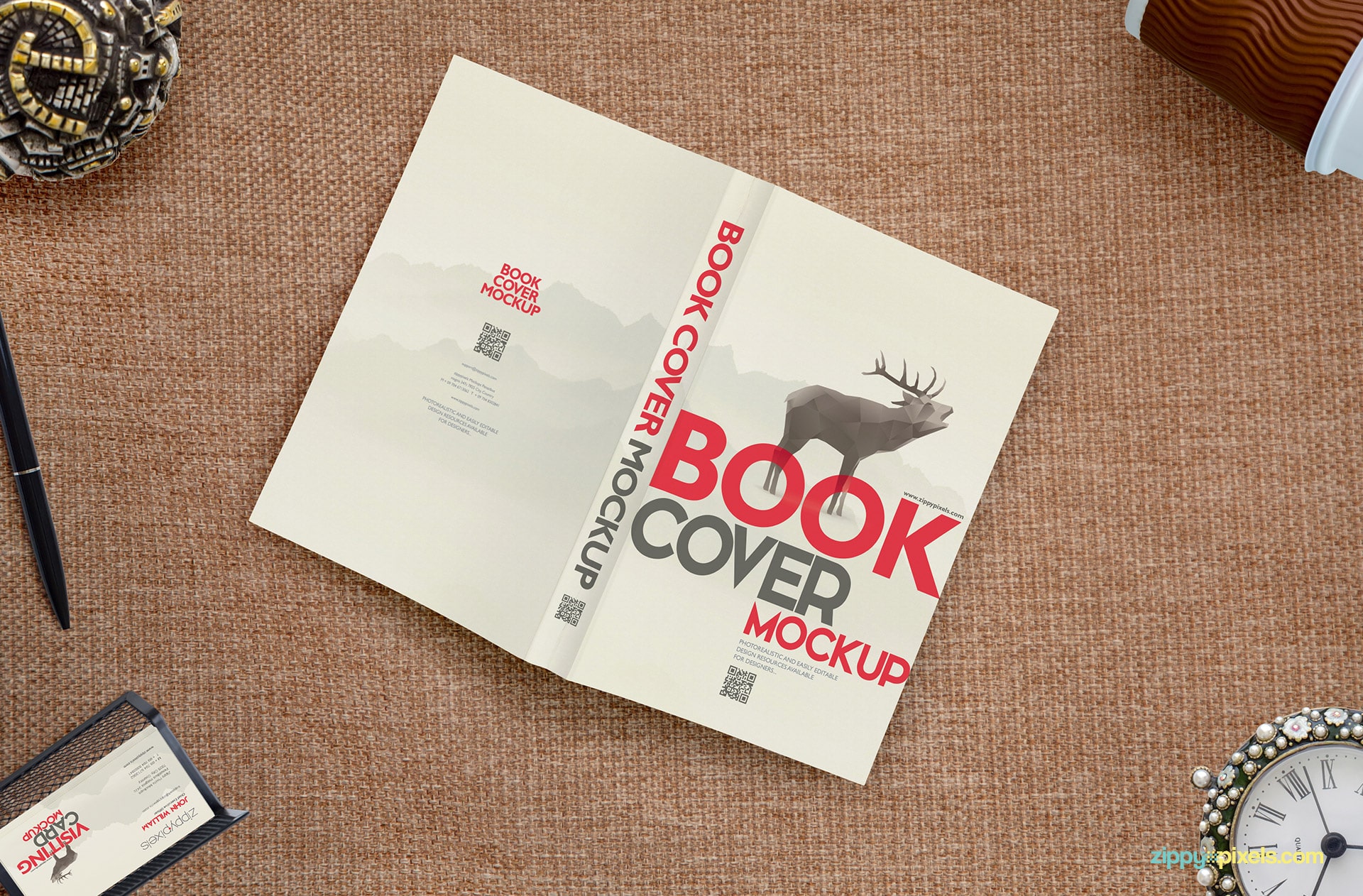 Full book cover mockup showing a book lying face down with coffee cup, business card holder, desk clock, jewelry box & ball pen