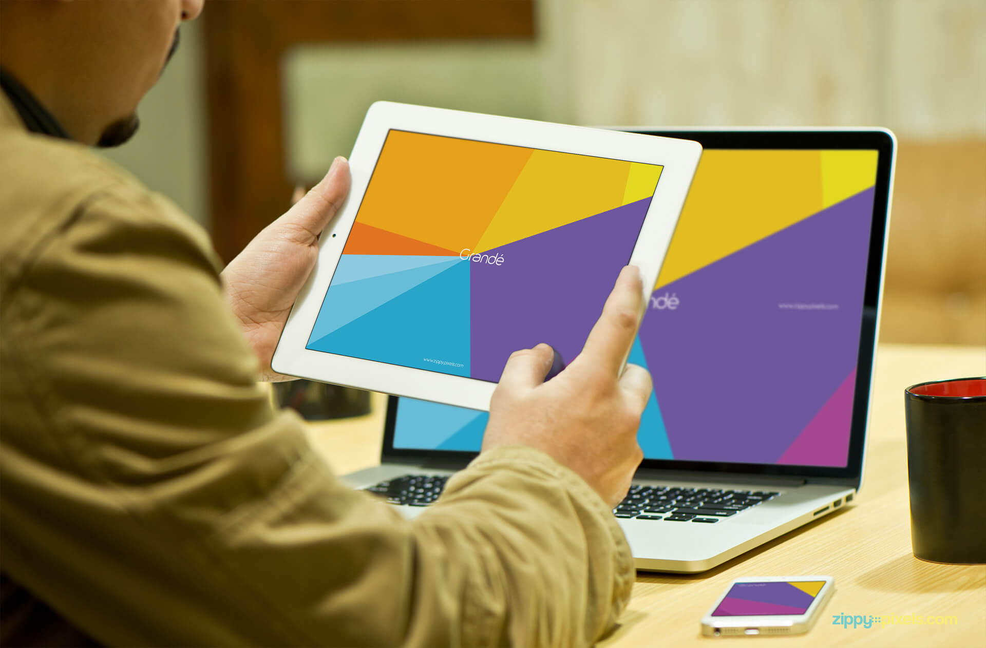 Device Mockup of a Person holding iPad and Macbook Pro in Background